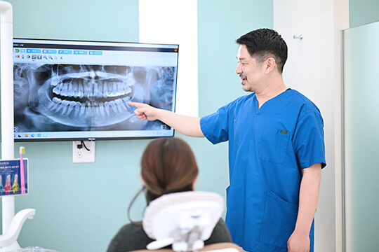 患者様に口腔内の説明をする院長